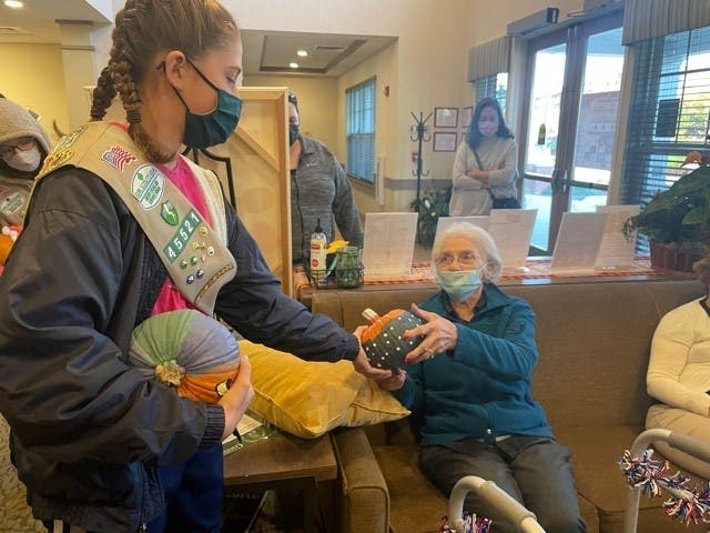 A member of Girl Scout Troop 45521 delivers a pumpkin to a resident. 