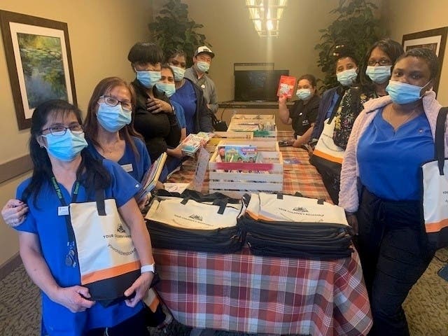 Emerald Place staff receive books in appreciation of their efforts. 