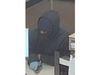 A suspect in two Thursday afternoon bank robberies is shown in this surveillance image with a gun. 