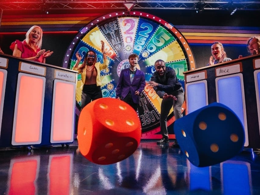 Great Big Game Show teams inside the studios step behind podiums to compete in a fast-paced, one-hour challenge.
