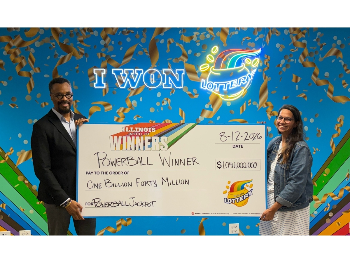 Illinois Lottery Director, Harold Mays (left), and Chicago Prize Center manager Amanda Crosas hold the big check representing the $1.04 billion Powerball jackpot from the Aug.12 drawing.