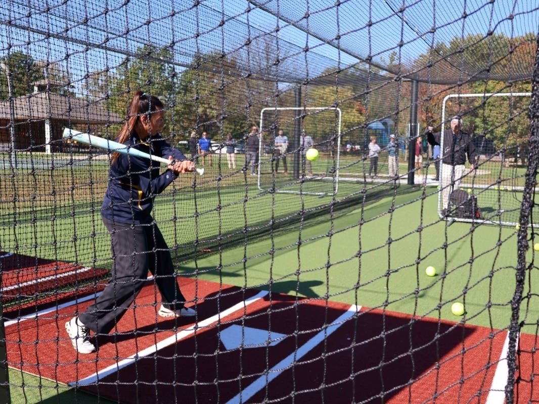 A softball player rakes batting practice in the new batting cages at Swenson Park. The facility provides Glenview Titans Fastpitch athletes with a dedicated space to practice and develop their hitting skills.
