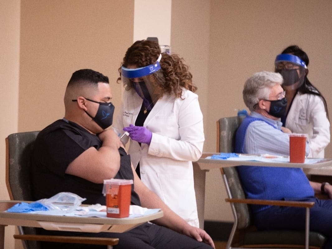 A Holy Name Medical Center employee receives on of the first coronavirus vaccines at the Teaneck hospital.
