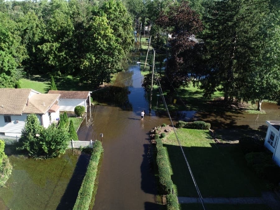 Ida brought heavy rains, raising river levels and causing flooding across the state. Pictured here, a man stands in a flooded street in the Crestview area of Wayne Township.