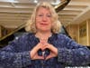 Linda Marks, a Waltham-based singer-songwriter, is pictured here giving Damar Hamlin's signature heart gesture. Marks wrote a song for Hamlin's mother, Nina, in following Hamlin's on-field cardiac arrest on Jan. 2.