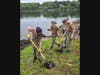 Younger Sea Cadets dig holes for fence posts.