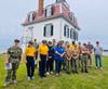 Friends of Pomham Rocks Lighthouse President Alex Dias, far right, Fence
Project Manager Rick Lux, second from right, and member Nikki Tiernan, in center with sunglasses thank the U.S. Naval Sea Cadets, Falcon Division for their help with the project.