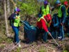 Volunteers from Coca-Cola Consolidated collect litter around the waterways of Oxon Run. 
