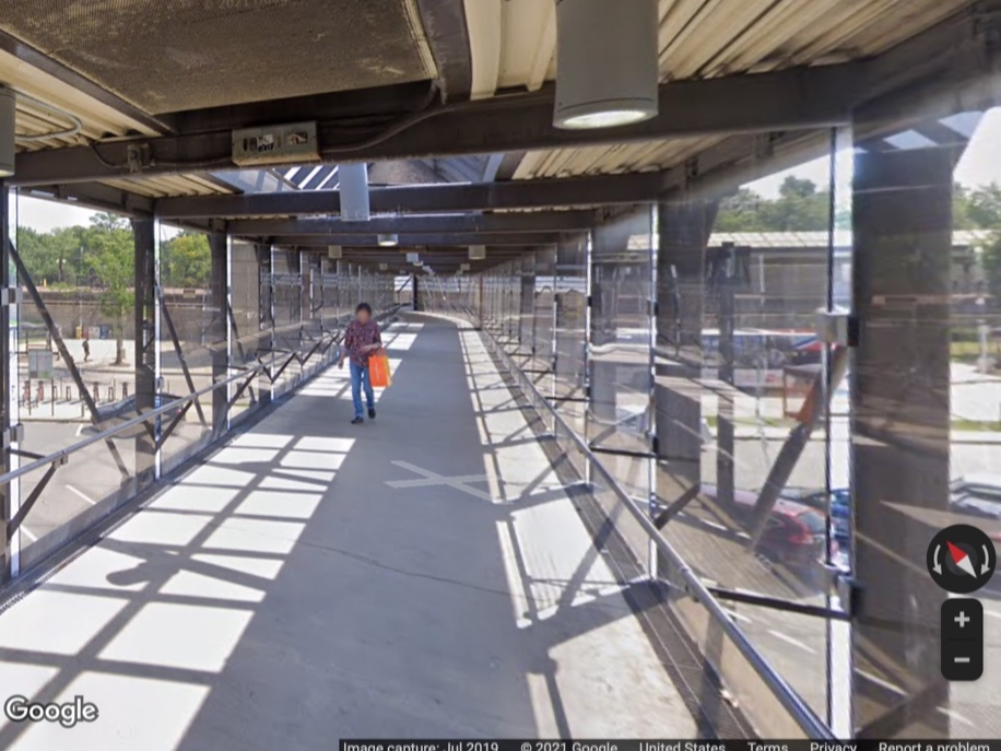 A pedestrian walks over the pedestrian bridge connecting the Town Center and the Metro Station in Rockville. The bridge reopened Monday after being closed for 14 months. 