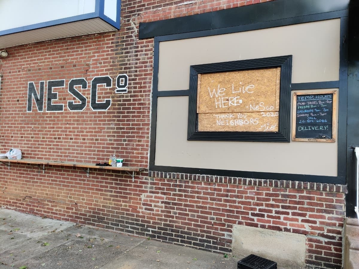 A boarded up window outside of NorthEast Sandwich Company.