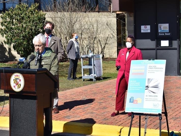 Anne Arundel County Public Library CEO Skip Auld announced Tuesday that the system will get rid of late fees. County Executive Steuart Pittman and Mizetta Wilson from the Partnership for Children, Youth and Families listen to Auld's speech.