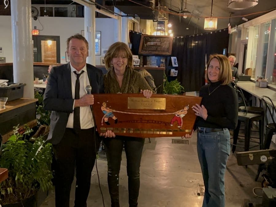 Annapolis Mayor Gavin Buckley, left, accepts the 2022 tug-of-war trophy from Maritime Republic of Eastport Premier Patti Slaughter, right.