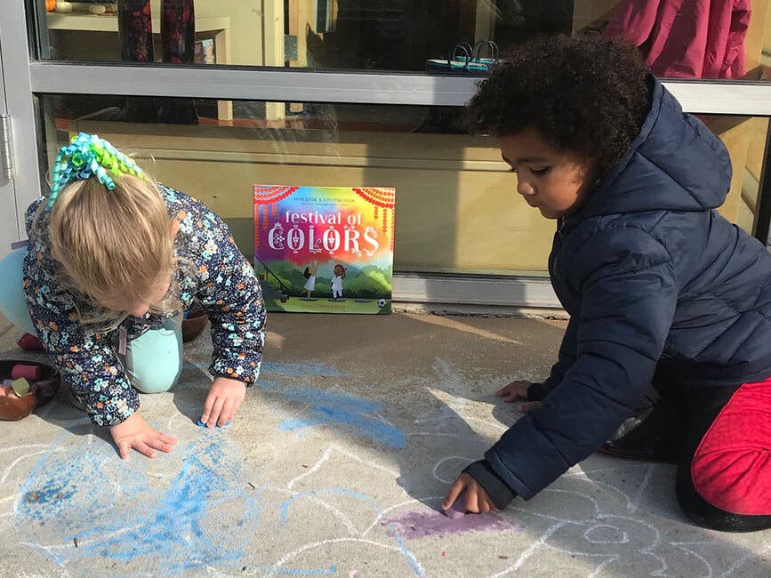 TU Child Care Center students draw a rangoli while learning about Diwali in November 2020.