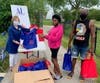 Assistance League member Carol Park distributing supplies for summer school