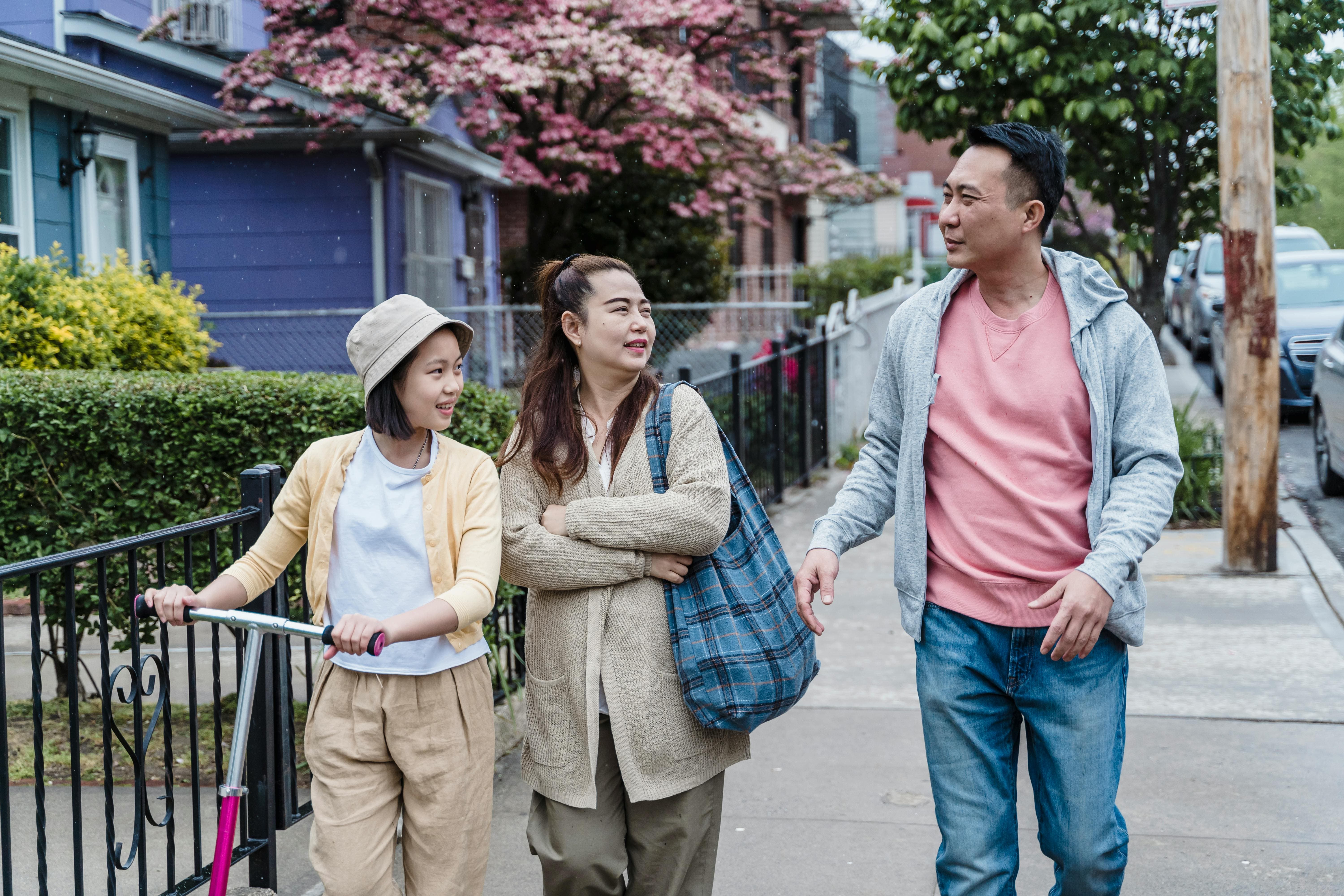 A family of three walking along a residential street