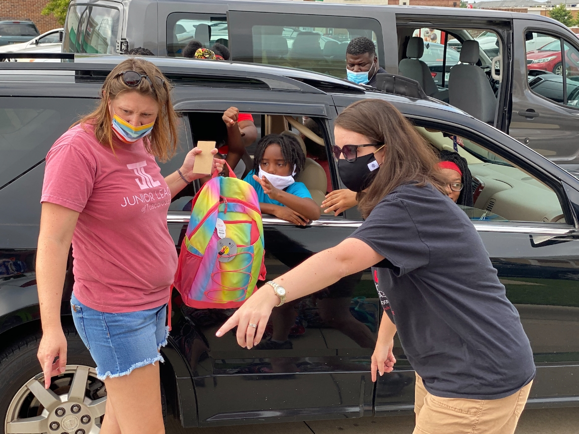 Volunteers point out different backpacks during the Operation Backpack event Saturday morning.