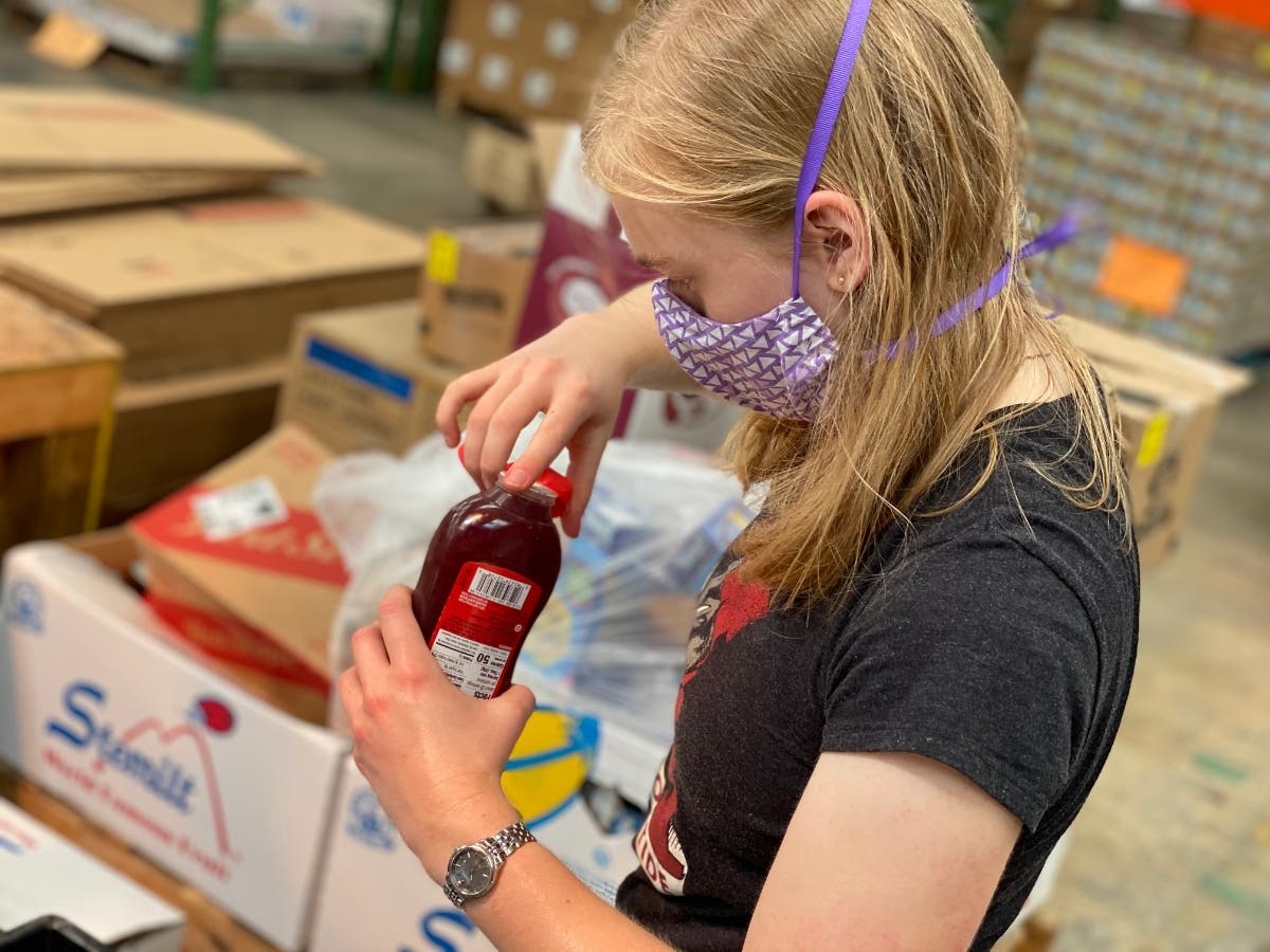 UA student and volunteer Bridget McMullin checks items as she sorts through boxes at the West Alabama Food Bank on Monday