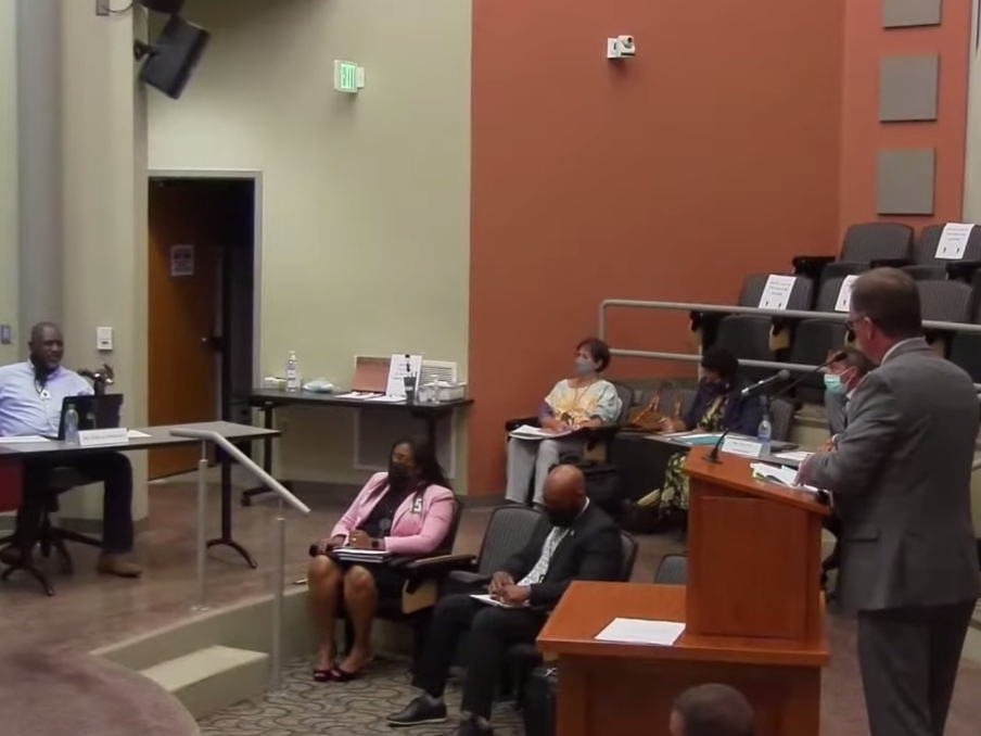 TCS Chief School Financial Officer​ Jay Duke (right) speaks at the podium during Tuesday's called meeting. 