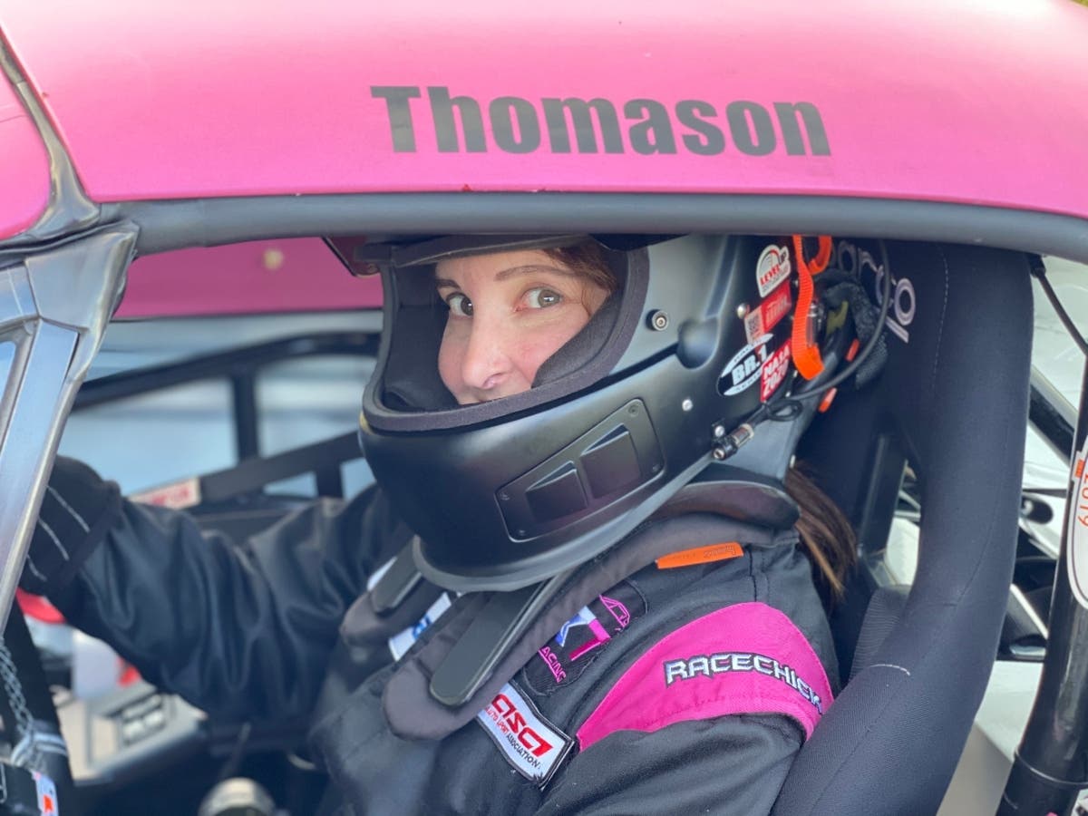 Ritamarie Thomason sits in her pink and white Mazda Miata 