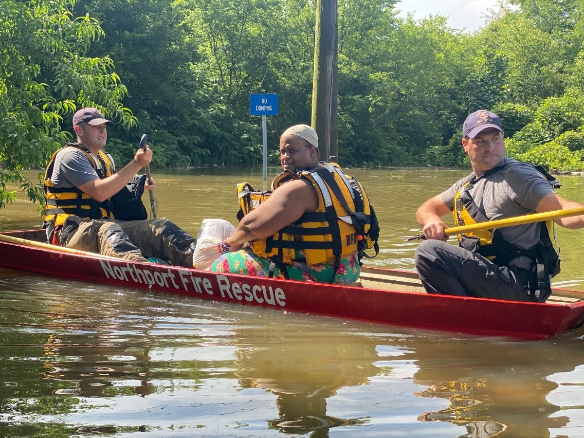 A woman is rescued from her home after it flooded on 6th Street in Northport Saturday evening. 
