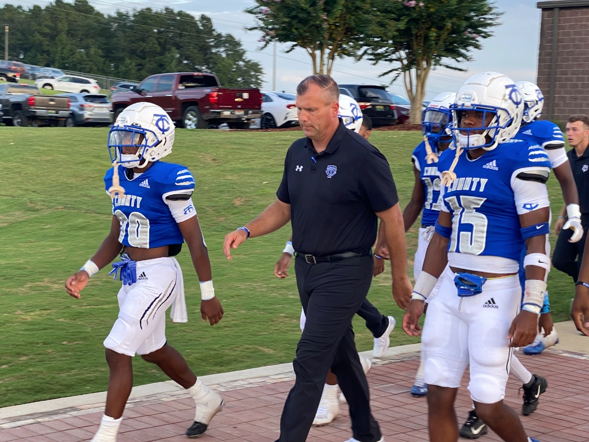Tuscaloosa County football coach Adam Winegarden leads his team onto the field over a new Legacy Walk. 