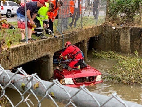 Crews work to get the submerged vehicle out of a drainage ditch. 
