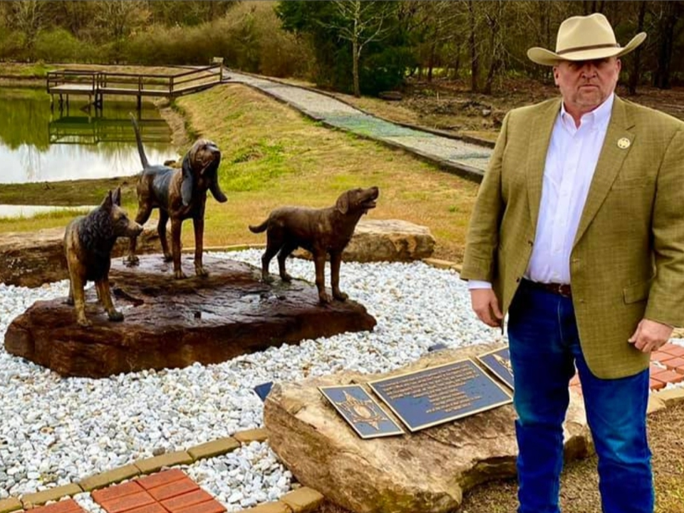 Sheriff Ron Abernathy poses in front of the new memorial at the county's K9 training facility. 