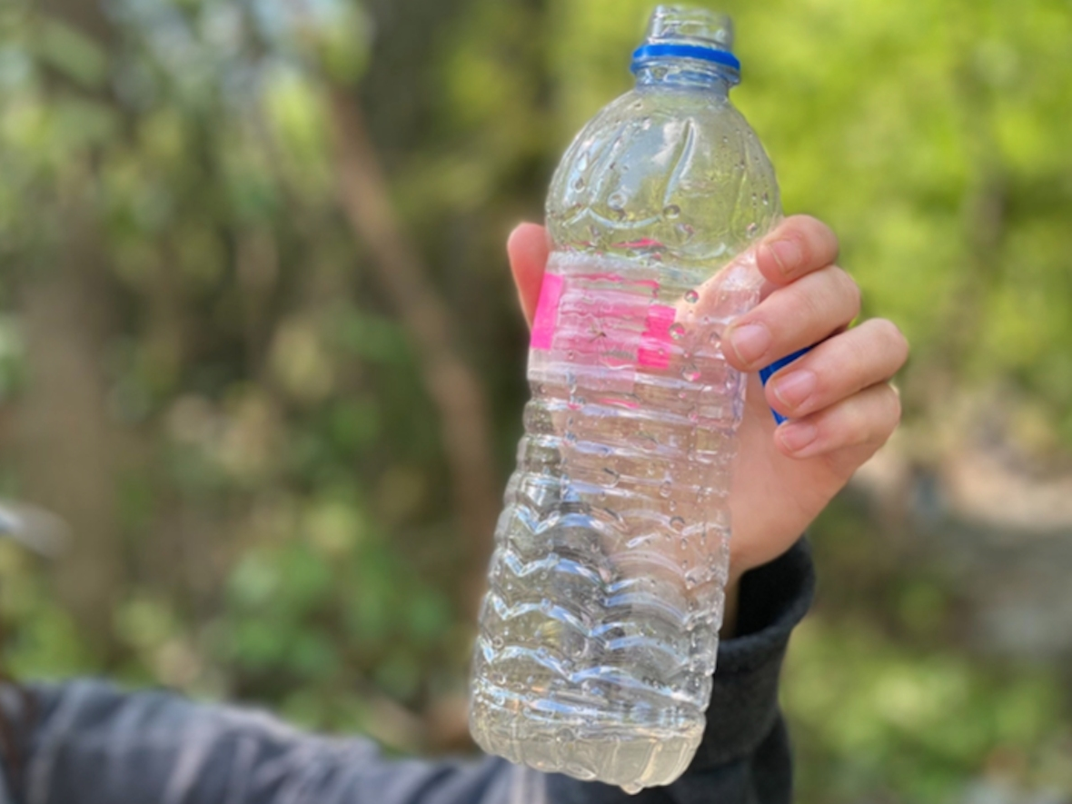 Palmetto Street resident Sam Key holds up a water sample from the spill site in April.