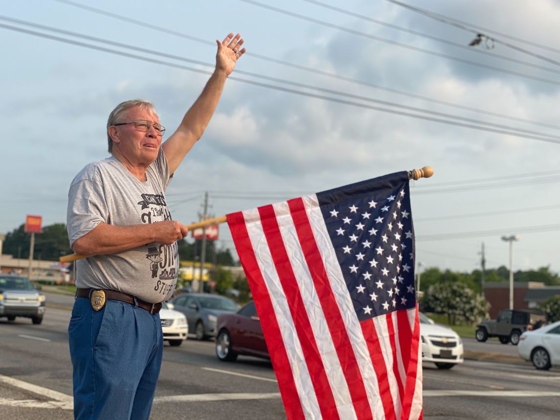 Northport Mayor Bobby Herndon waves to passing motorists on July 4, 2021 