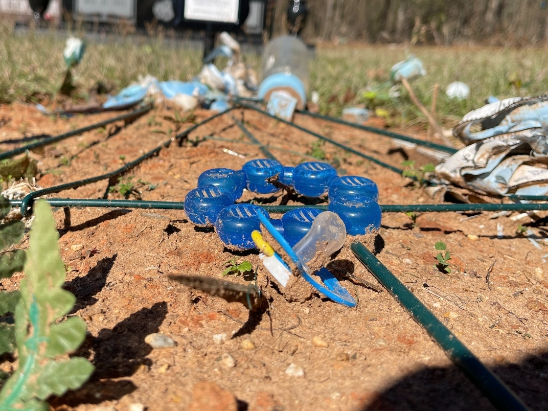 Several baby items are scattered about Greyson Gray's neglected grave at Bone Camp Cemetery