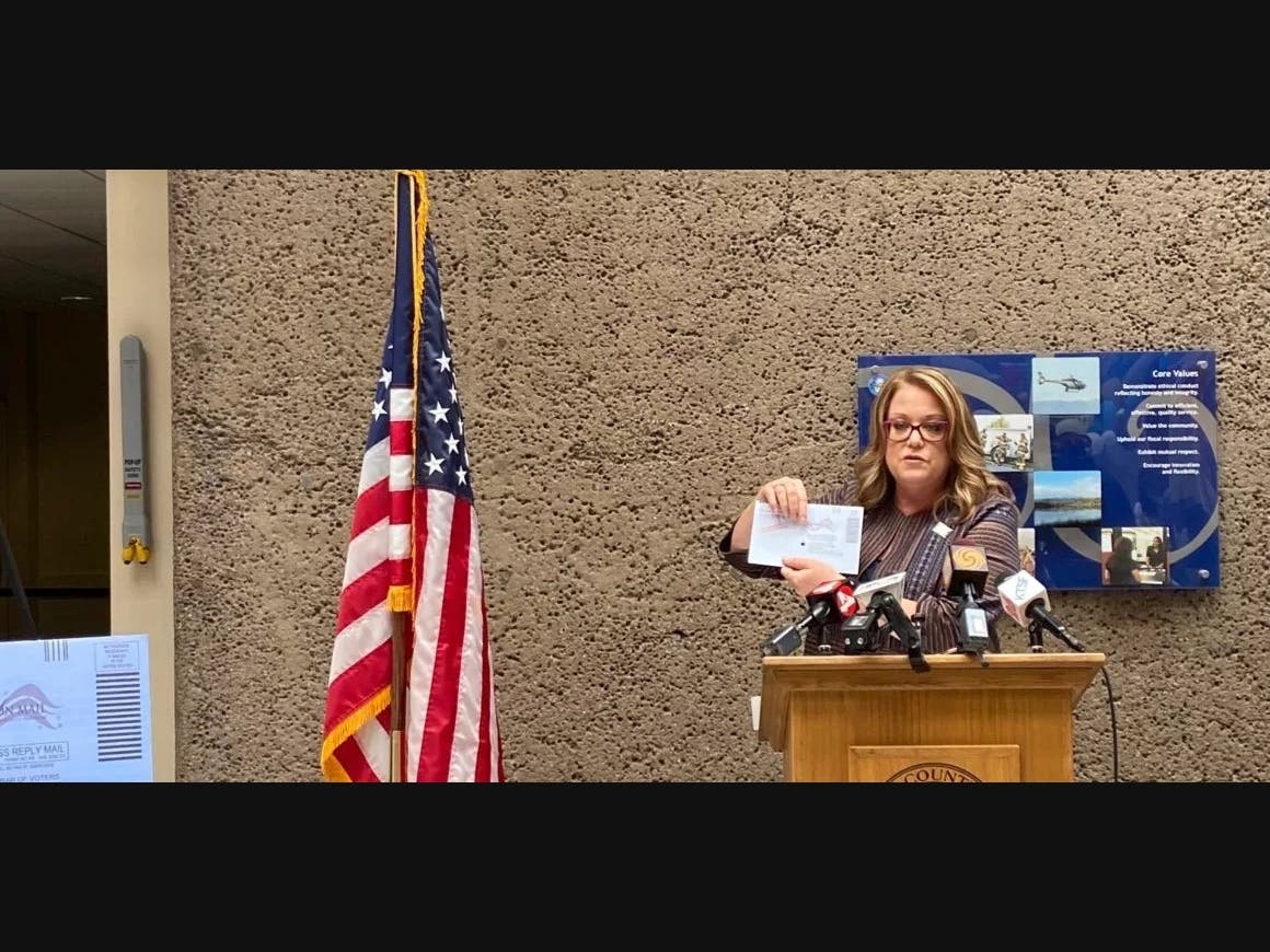 Shannon Bushey, registrar of voters for Santa Clara County, shows a mail-in ballot at an Aug. 25 news conference. 