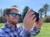 A viewer experiences “The Time Traveler's Lens” as augmented reality on the Princeton Battlefield park grounds