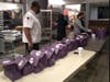 Campus Dining team members Orlando Griffiths, retail food service worker (left); Marie Deravil, retail food service worker; and Maria Datuin, operations manager, prepare bagged meals in one of Princeton’s dining facilities. 