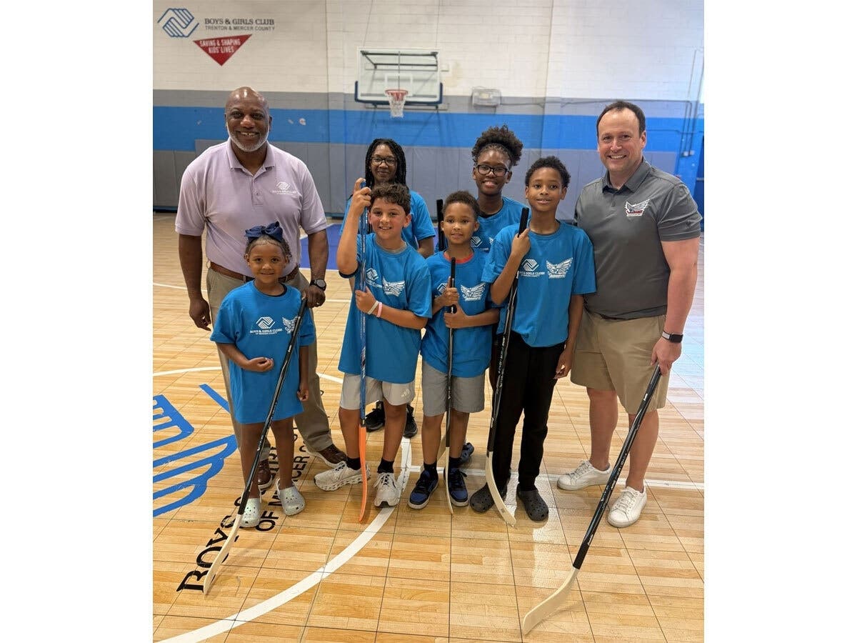 Trenton Ironhawks Head Coach Chuck Weber and Boys & Girls Clubs of Mercer County President and CEO Reginald J. Coleman gather with Club members after an afternoon of hockey in the gym