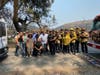 Thao Le and husband Vince Ones pose for a photo with volunteers, police and fire crews after evacuating the animals from Lucky Ones Ranch. 