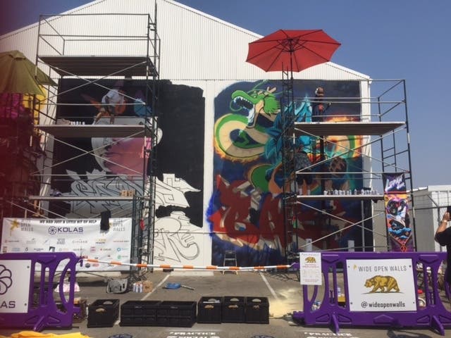 Artists work on scaffolds painting murals in Sacramento public spaces for the annual "Wide Open Walls" art festival.