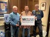 The one millionth guest, Larry McKillop (left), Matt Garris, Freedom Center operations manager (center) and military lounge volunteer Brian Bartlett (right).