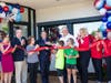 Trustees Mary Beth Canty, Richard Baldino, Robin LaBedz, Mayor Tom Hayes, Dr. Bryan Nakfoor and his children, Grant and Morgan Nakfoor; Nak4 team members Jo Ann Dudzienski, Carol Lindsay, Joan Ziegler tie the ribbon on 602 W. Northwest Highway.