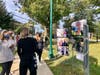 Attendees view a series of masked portraits at the exhibit "Summit Under Quarantine" on the Village Green.