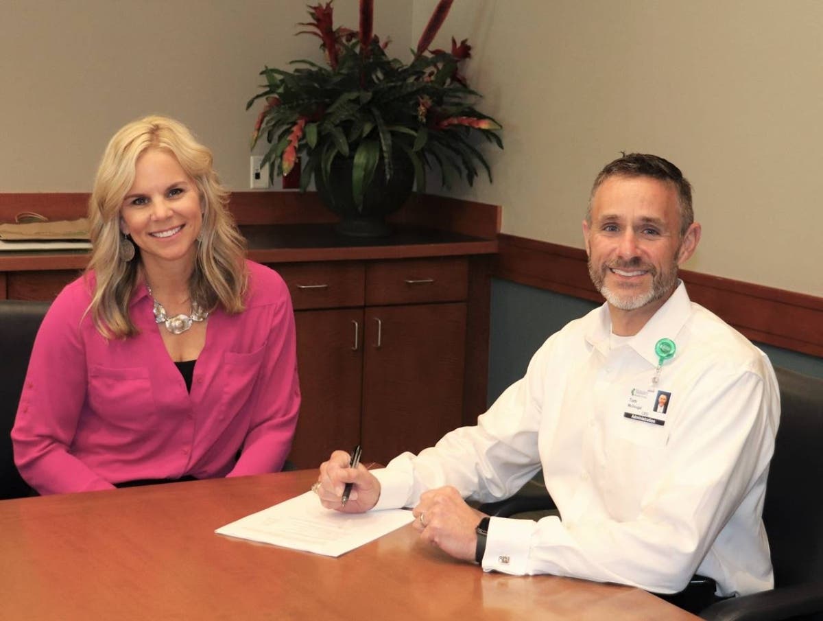  

Kristi Hoskinson, vice president of CareerEdge, and Tom McDougal, CEO of Manatee Memorial Hospital, sign a grant agreement. CareerEdge gave the hospital system $42,500 for upskilling workers.