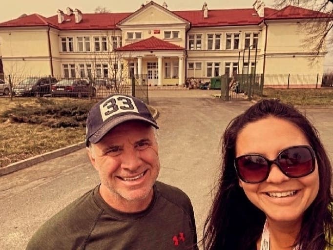 A Sarasota woman and an Arizona man connected on Facebook over their desire to help Ukrainian refugees during the war. Weeks later, they met in Poland for the first time. They're pictured in front of a school converted into housing for refugees.