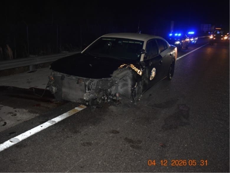 A Sarasota man was arrested after crashing into an empty patrol car on I-75, FL troopers said. Debris from the crash hit and seriously injured a trooper helping a disabled motorist nearby.