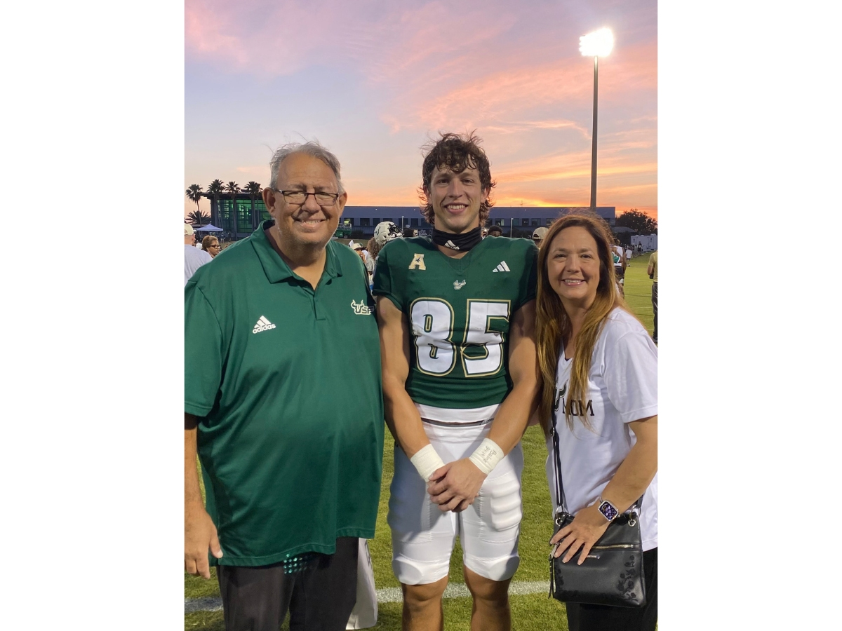 USF football alum Christian Helms just marked his 50th daily 1-mile run as he raises awareness of his father’s need for a kidney transplant. Helms, center, is pictured with his parents.