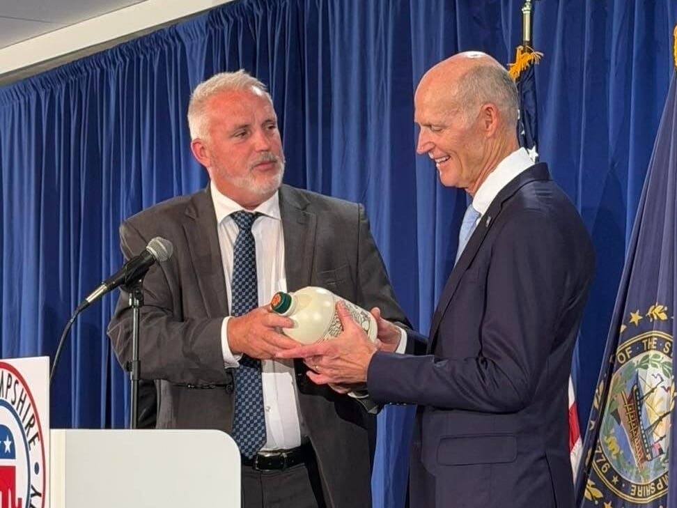 State Sen. Howard Pearl (R-Loudon) presents U.S. Sen. Rick Scott (R-Fla.) with a half-gallon bottle of maple syrup harvested from his family farm at the NHGOP's annual Amos Tuck Dinner in Concord on Sept. 18, 2026.