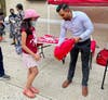 Amir Sobhraj, Financial Controller of Zara Realty, hands a backpack to a student at the back-to-school giveaway.
