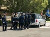 The colleagues of Candice Ogiejko place her casket into a hearse outside of St. Gerard Magella in Port Jefferson Station on Monday.