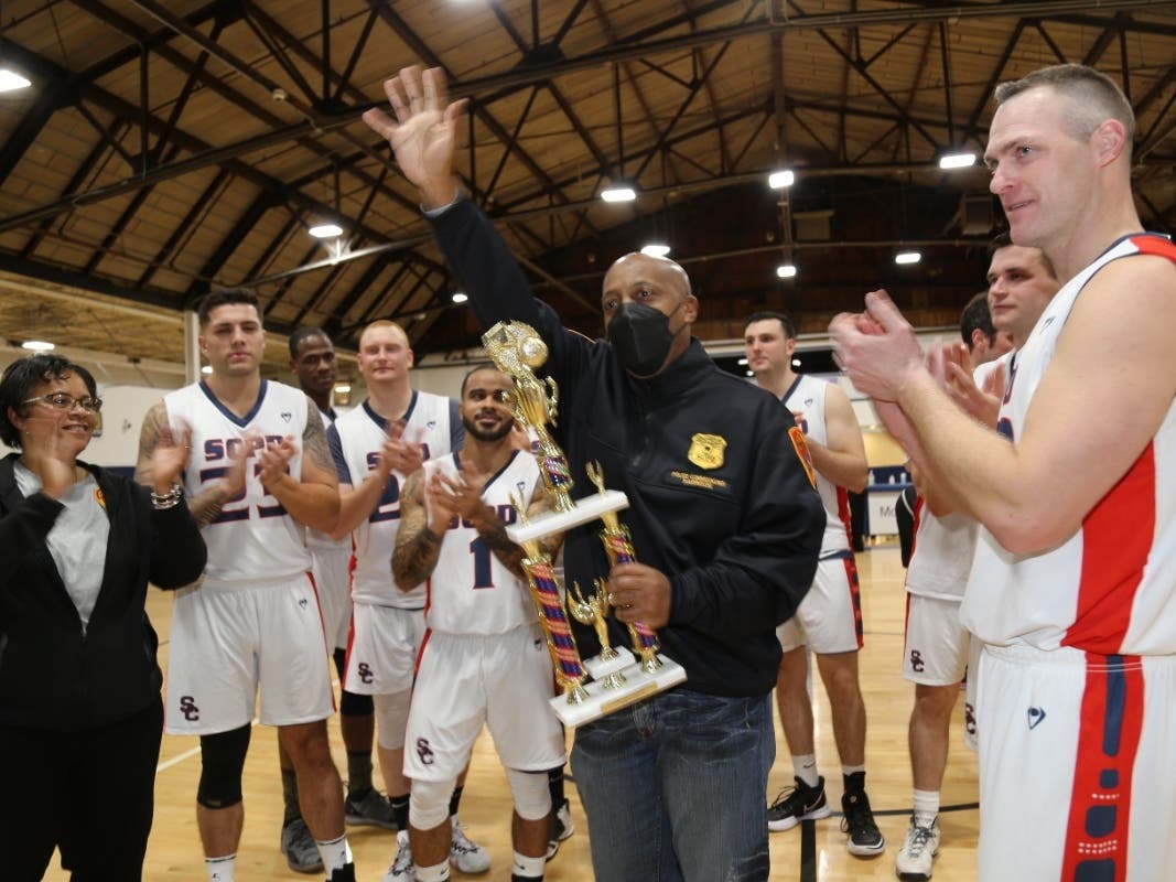 Suffolk Police Commissioner Rodney Harrison with the basketball teams on Saturday in West Hempstead.