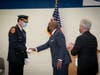 Suffolk Police Commissioner Rodney Harrison presents Chief of Department Robert Waring with his new shield as County Executive Steve Bellone looks on.