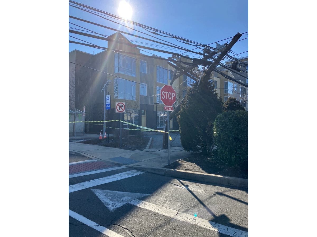 A utility pole - one of four put out of commission - is snapped in half, dangling over Terry Street in Patchogue on Monday afternoon