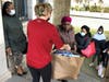 A volunteer hands a bag filled with gifts to a person in need at the Archdiocese of Newark Mercy House’s annual Christmas Toy Giveaway on December 17, 2021.